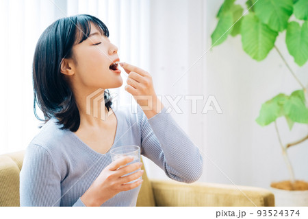 薬を飲む女性 93524374