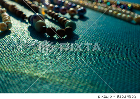 Heap of colored bright jewelry beads on a blue background. Different gems beads necklace. Jewel necklace modern fashion pattern or texture. copy space. Heap of colored bright jewelry beads on a blue background. Different gems beads necklace. Jewel necklace modern fashion pattern or texture. copy space. 93524955