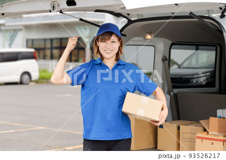 軽貨物自動車に荷物を積み込むガッツポーズの女性。配送や引越し業者のイメージ。 93526217