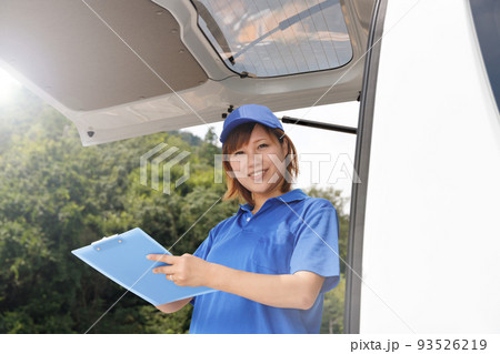 軽貨物自動車のドライバーの女性がバインダーと筆記用具を持っている。引越し業者や配送の仕事をしているイ 軽貨物自動車のドライバーの女性がバインダーと筆記用具を持っている。引越し業者や配送の仕事をしているイ 93526219