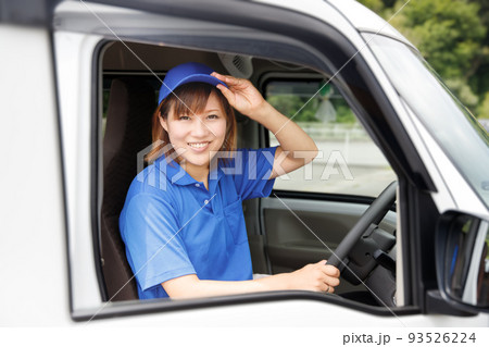 女性ドライバーが笑顔で荷物届ける。物流、宅配、引越し業者のイメージ。 女性ドライバーが笑顔で荷物届ける。物流、宅配、引越し業者のイメージ。 93526224