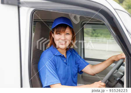 青い帽子とポロシャツを着て運転する女性。引越し、配送ドライバーのイメージ。 93526225