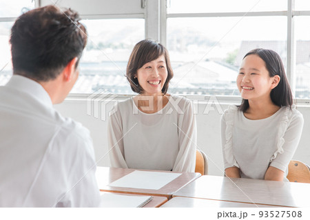 教室で三者面談をする担任の先生と親子（進路相談） 93527508