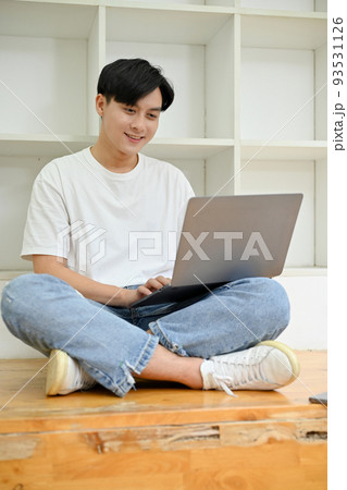 Handsome Asian male college student in library co-working space, using laptop 93531126