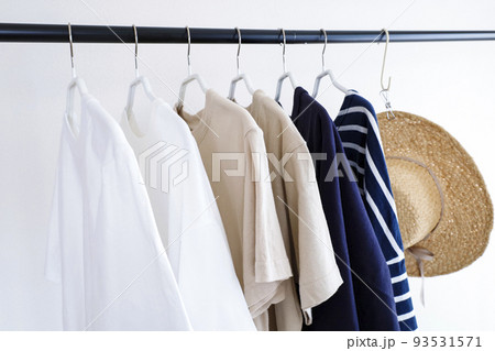 ハンガーラックに並んだ洋服と帽子 93531571