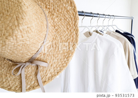 ハンガーラックに並んだ洋服と帽子 93531573
