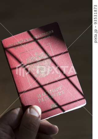 Russian passport in the hands of a man. Prohibition of Schengen visas for Russian tourists to travel to the European Union concept. Russian passport in the hands of a man. Prohibition of Schengen visas for Russian tourists to travel to the European Union concept. 93531873