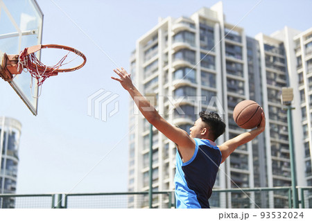 young asian adult dunking basketball on outdoor court young asian adult dunking basketball on outdoor court 93532024
