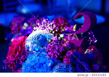 decorated in disco style table in a dark banquet hall.  decorated in disco style table in a dark banquet hall.  93533165