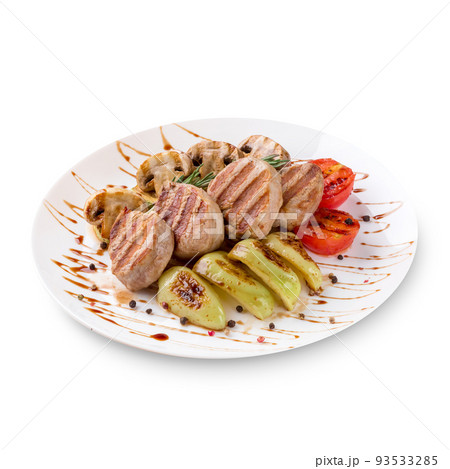 Plate of grilled steaks meat with vegetables on white background Plate of grilled steaks meat with vegetables on white background 93533285