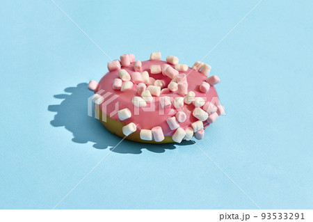 Food design. Close up high quality image of pink glazed donut on blue background Food design. Close up high quality image of pink glazed donut on blue background 93533291