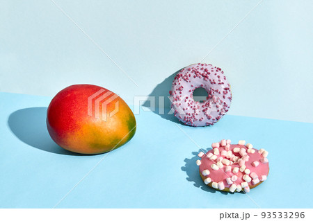 Composition of fresh fruits and sweets, two donuts and juicy mango 93533296