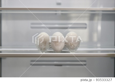 新品の冷蔵庫の棚に置いてある6個入りのパック白卵 93533327