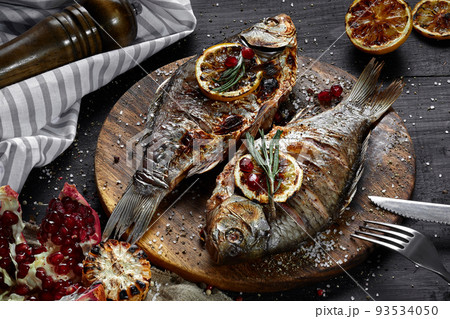 Grilled carp with lemon on wooden board, horizontal view from above close-up Grilled carp with lemon on wooden board, horizontal view from above close-up 93534050