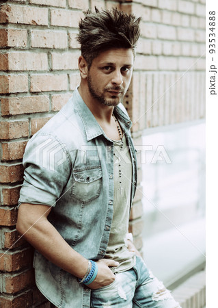 Portrait of handsome man in casual clothing posing on the street, looking away to a side. Color Toned Image. Concept urban man. 93534888