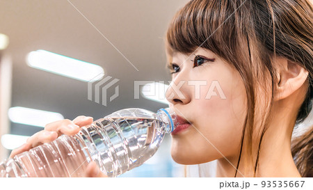 スポーツジムで水分補給をする若い女性 スポーツジムで水分補給をする若い女性 93535667
