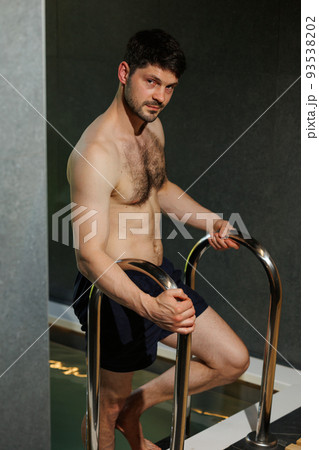 Attractive man after a sauna goes down to the pool Attractive man after a sauna goes down to the pool 93538202