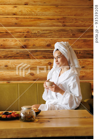 Relaxed girl drinking tea after sauna Relaxed girl drinking tea after sauna 93539108