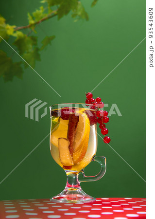 Glass of delicious aromatic citrus tea with lemons, ginger, mint, honey and cinnamon stick isolated over green background 93543609