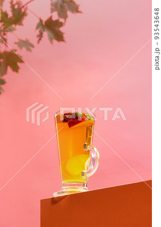 Glass of delicious aromatic fruit tea with citrus, lemons, mango, honey and anise isolated over pink background Glass of delicious aromatic fruit tea with citrus, lemons, mango, honey and anise isolated over pink background 93543648