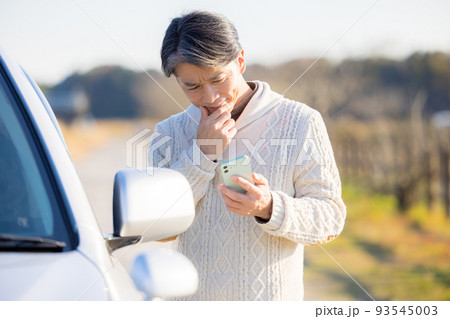車が故障して電話をかけるミドル男性 93545003