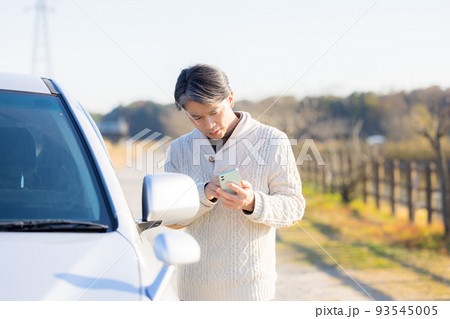 車が故障して電話をかけるミドル男性 93545005
