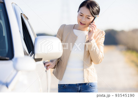 車が故障して電話をかけるミドル女性 93545190