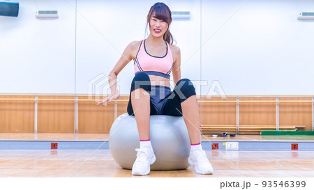 バランスボールに挑戦する若い女性 バランスボールに挑戦する若い女性 93546399