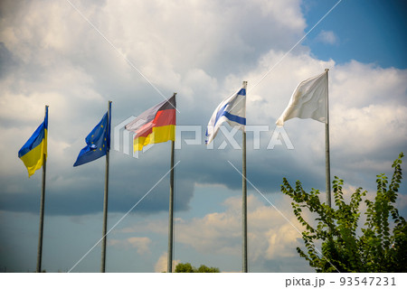 The flag of the European Union and flags of Ukraine, Israel, Germany flutter in the wind in different directions against the blue sky. Bottom side view 93547231