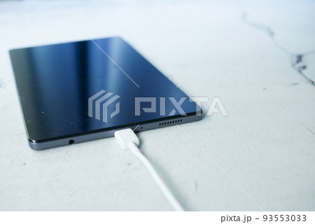 charging s digital tablet with a cable on white background charging s digital tablet with a cable on white background 93553033