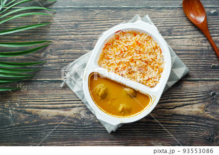 curry chicken and rice in a take away plastic packet on table curry chicken and rice in a take away plastic packet on table 93553086