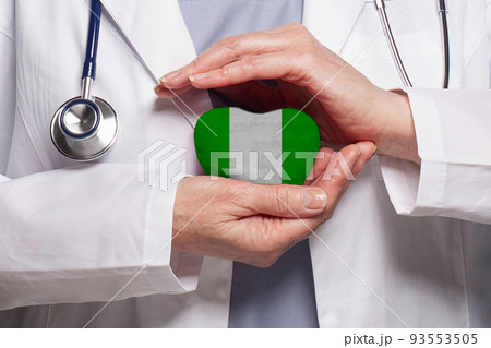Nigerian doctor holding heart with flag of Nigeria background. Healthcare, charity Nigerian doctor holding heart with flag of Nigeria background. Healthcare, charity 93553505