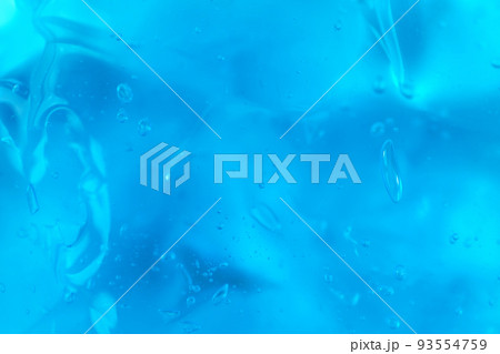 Texture of transparent antiseptic gel with air bubbles on blue background. Summer ocean imitation. Concept of skin moisturizing, prevention of virus. Liquid beauty product closeup. Backdrop, flat lay Texture of transparent antiseptic gel with air bubbles on blue background. Summer ocean imitation. Concept of skin moisturizing, prevention of virus. Liquid beauty product closeup. Backdrop, flat lay 93554759