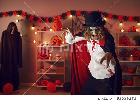 Portrait of an adult man dressed up in a spooky Halloween costume of an evil vampire 93556283
