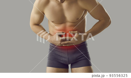 Man who suffers from digestive disorder and stomachache holding hands on his abdomen Man who suffers from digestive disorder and stomachache holding hands on his abdomen 93556325