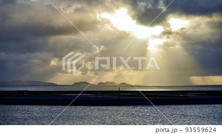光が射す空と那覇空港滑走路と慶良間諸島 93559624