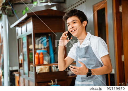 male seller makes a call using a mobile phone 93559970
