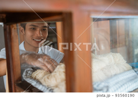 young seller man taking noodles while selling 93560190
