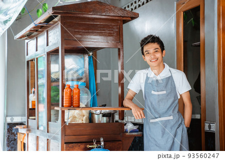 Smiling man selling standing next to a cart Smiling man selling standing next to a cart 93560247