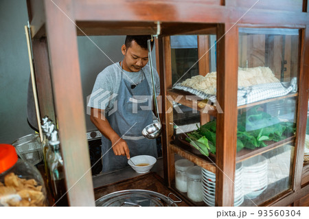 man seller in apron stir the spices in the bowl man seller in apron stir the spices in the bowl 93560304