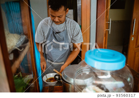 man seller in apron prepare the seasoning in the bowl 93560317