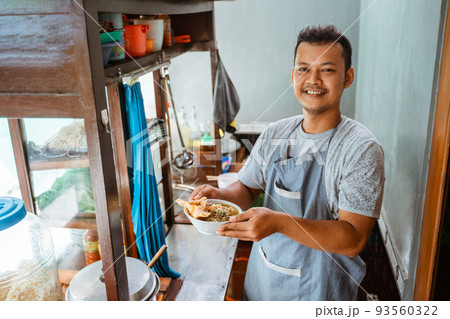 man seller smiling brought a bowl of chicken noodles 93560322