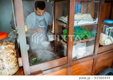 the seller takes the flavoring when preparing of chicken noodles the seller takes the flavoring when preparing of chicken noodles 93560444