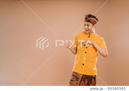 balinese young man presenting and pointing to copyspace 93560565