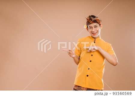 balinese young man presenting and pointing to copyspace 93560569