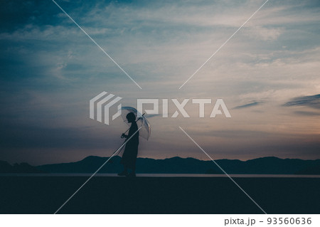 女性のシルエットと美しい夕焼け空 女性のシルエットと美しい夕焼け空 93560636