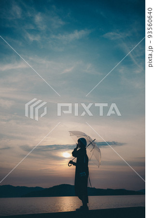 女性のシルエットと美しい夕焼け空 93560640