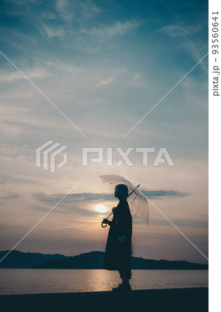 女性のシルエットと美しい夕焼け空 女性のシルエットと美しい夕焼け空 93560641