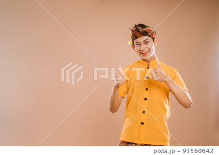 balinese young man presenting and pointing to copyspace 93560642