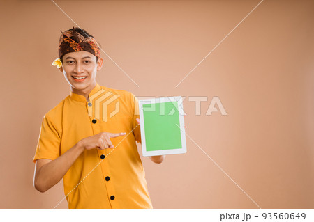 balinese young man using tablet pc showing the screen 93560649